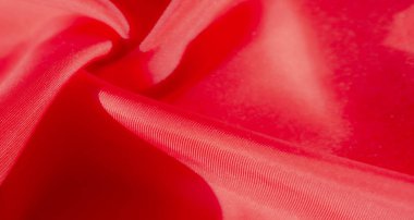 Akan kırmızı bir kumaş, ince bir hareketle yakalanıp ipeksi yüzeyinde ışık ve gölge arasındaki etkileşimi gözler önüne seriyor. Lüks katlar gösterişli, yüksek moda bir duygu taşır..