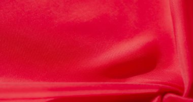 Yumuşak ve soyut dalgalar halinde akan canlı kırmızı bir kumaşın yakın çekimi. Doku ve kıvrımlar zarif, dinamik bir etki yaratıyor. İpeksi pürüzsüzlük ve parlak renkle güçlendirilmiş..