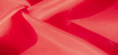 Yumuşak kıvrımları, ince kıvrımları ve röfleleri olan ipek gibi kırmızı bir kumaş. Parlak renk ve parıltı lüks ve zarif bir izlenim yaratır. Moda ve tasarım için mükemmeldir..