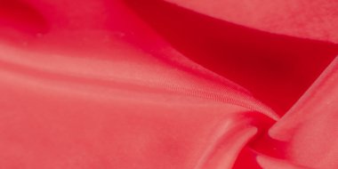 Yumuşak kıvrımları, ince kıvrımları ve röfleleri olan ipek gibi kırmızı bir kumaş. Parlak renk ve parıltı lüks ve zarif bir izlenim yaratır. Moda ve tasarım için mükemmeldir..