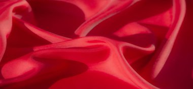 Bu makro çekim pürüzsüz, akıcı bir dokusu olan zengin kırmızı kumaşa sahiptir. Işık yumuşak kıvrımların ve yumuşak kıvrımların altını çiziyor, maddenin lüks ve ipeksi doğasını vurguluyor..