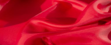 Yumuşak kıvrımlı güzel katlanmış kırmızı bir kumaş ve pürüzsüz yüzeyini aydınlatan parlak bir kaplama. Kumaş zarif bir akış yaratır, ışık rengin derinliğini ve zenginliğini arttırır..