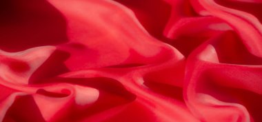 Zarif bir akış oluşturan yumuşak dalgalı kıvrımları olan zengin kırmızı bir kumaş. Kumaşın üzerindeki ışık ve gölge oyunu onun pürüzsüz dokusunu ve lüks parıltısını ön plana çıkararak, moda için ideal hale getiriyor.