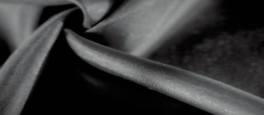Kumaşın hareketini ve dokusunu vurgulayan yakın çekim kumaşı. Monokrom palet kıvrımların derinliğini arttırır. Görüntüye sofistike ve huzurlu bir ton verir..