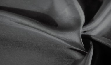 Bu görüntü zarif kıvrımları ve gri kumaşın yumuşak dokusunu ince gölgeler ve gölgeler ile yakalar. Pürüzsüz, akışkan çizgiler kompozisyona huzur katar..