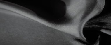 Bu görüntü zarif kıvrımları ve gri kumaşın yumuşak dokusunu ince gölgeler ve gölgeler ile yakalar. Pürüzsüz, akışkan çizgiler kompozisyona huzur katar..