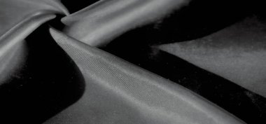 Açıklama: Yumuşak, akışkan kumaşın hafif ışık yansımaları nazik kıvrımlar ve dalgalanmalar oluşturur. Kumaşın dokusu ışık ve gölge arasındaki kontrastla vurgulanır..