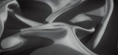 Yumuşak dalgalarda zarafetle katlanmış akışkan kumaşın detaylı bir görüntüsü. Işık ve gölge oyunu dokuya derinlik katıyor, sakinlik ve karmaşıklık hissi uyandırıyor..