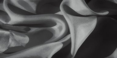 Yumuşak kumaş dalgaları, zengin dokusunu vurgulayan yumuşak ışıklandırmayla soyut bir desen oluşturur. Katlar dinamik ve dinamik bir etki yaratıyor, sofistike bir görsel deneyim sunuyor..