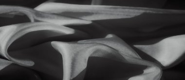 Yumuşak kumaş dalgaları, zengin dokusunu vurgulayan yumuşak ışıklandırmayla soyut bir desen oluşturur. Katlar dinamik ve dinamik bir etki yaratıyor, sofistike bir görsel deneyim sunuyor..