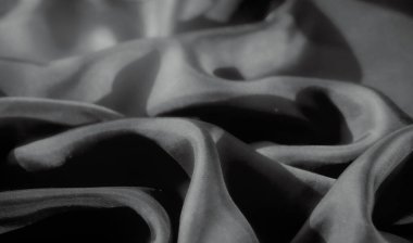 Pürüzsüz kıvrımlı, tek renkli kumaş akışı. Işık ve gölgenin etkileşimi dokuyu güçlendirir, malzemeyi yumuşak ve narin gösterir..