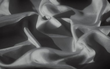 Yumuşak kıvrımlı, tek renkli bir kumaş. Işık ve gölgenin oyununu gösteriyor. Görüntü, asgari ve soyut bir arkaplan için mükemmel lüks ve dalgalı dokuyu vurgular.