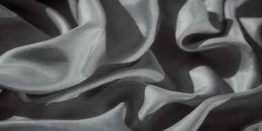 Yumuşak gölgeler ve dokuyu vurgulayan işaretlerle zarif kıvrımlara sarılmış büyüleyici bir kumaş. Işık oyunu, kumaşın akışının huzurlu ve sanatsal bir tasvirini yaratır..