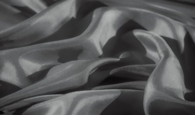 Görüntü, yumuşak dalgalanan dalgalarla kumaşın akıcılığını yakalıyor. Minimalist ve sofistike bir görüntü sunuyor. Kumaşın ince dokusu doğal ışıklandırmayla vurgulanır.