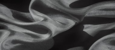 Görüntü, yumuşak dalgalanan dalgalarla kumaşın akıcılığını yakalıyor. Minimalist ve sofistike bir görüntü sunuyor. Kumaşın ince dokusu doğal ışıklandırmayla vurgulanır.