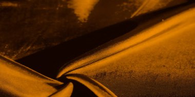 Altın renkli kumaşın çarpıcı bir görüntüsü zarif bir şekilde katlanmış, dinamik ışıklandırma dokunun ince detaylarını vurguluyor. İnce bir parıltı karmaşıklık ve zenginlik hissi yaratır..