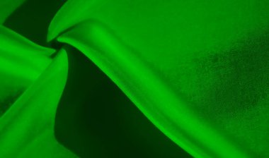 Özet olarak, karmaşık kıvrımlı yeşil bir kumaşı ele alalım. Yeşilin zıt gölgeleri, ışık ve gölgenin kesişimine odaklanarak, dinamik bir hareket hissi verir..