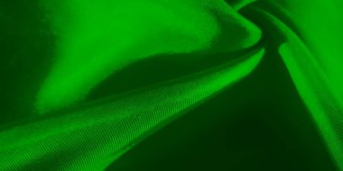 Yumuşak kıvrımlar halinde pürüzsüz, akışkan dokusunu gösteren minimalist bir yeşil kumaş görüntüsü, ışık ve gölge ipek yüzeyini vurgulayan dinamik ama dinamik bir bileşim oluşturuyor..