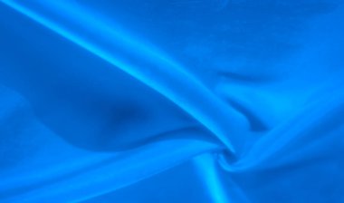 Yumuşak, akışkan mavi kumaş ince kıvrımlar ve kıvrımlar halinde, dokunsal dokusu ışıkla vurgulanmış. Nazik örtü, hareketin ve huzurun uyumlu bir karışımını yaratır..