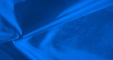 Yumuşak, akışkan mavi kumaş yakın plan hipnotik bir hareket hissi yaratıyor. Işıklandırma akış eğrilerini ve pürüzsüz dokuları vurgular, kumaşın ince detaylarını hayata geçirir..