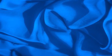 Yumuşak, mavi kumaş kıvrımlı ve pürüzsüz akarken ince ışık yansımaları derinlik katıyor. Görüntü, soyut tasarımlar için mükemmel, sakin ve minimalist bir ruh hali yakalar..