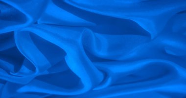 Çarpıcı soyut mavi kumaş, karmaşık dokular ve sıvı kıvrımlar sergiliyor. Koyu mavi renkler sükunet hissi uyandırırken, kumaşlar hareket ve zarafeti işaret ediyor.