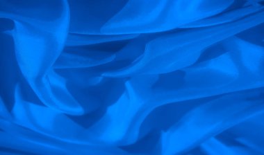Mavi kumaşın bu soyut yakın çekimi yumuşak dokulara ve nazik kıvrımlara sahiptir. Akan kumaş rahatlatıcı, zarif bir görsel yaratıyor, koyu mavi tonlar ve ince ışıklandırma efektleri ile güçlendiriliyor..