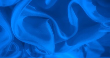 Sıkıca çerçevelenmiş mavi kumaş soyutu ince ışıklandırma varyasyonları ve karmaşık doku ayrıntıları ile dinamik bir akış oluşturan hassas kırışıklıklar ve eğriler sergiler.