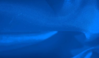 Yumuşak ışıklandırma mavi kumaşın akıcılığını ve dokusunu vurgular, dinamik girdaplar ve kıvrımlar oluşturur. Yakın çekim, materyallerin zarif eğrilerinin soyut kalitesini vurgular.