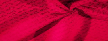 Her yerde geometrik izi olan parlak kırmızı bir kumaş, açısal semboller ve temiz çizgiler içeriyor. Kumaşın kıvrımları dinamik gölgeler oluşturarak tasarımın derinliğini arttırır..