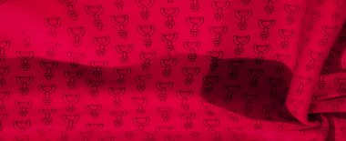 Tekrarlayan siyah geometrik desenli kırmızı kumaştan oluşan sanatsal bir düzenleme. Nazikçe kıvrılıp hareket ederken materyalin zarafetini yakalıyor. Moda tasarımı için mükemmel bir zemin.