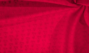 Üniformalı siyah soyut bir tasarım ile süslenmiş kırmızı kumaş, minimalist ama çarpıcı bir kontrast oluşturuyor. Kumaştaki kıvrımlar, maddenin derinliğini artıran doğal gölgeler sunuyor.