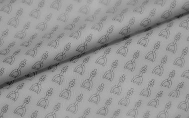 Kumaşın pürüzsüz yüzeyi ince, tek renkli bir dizaynda tekrarlanan üzengi şekillerinin karmaşık bir modelini ortaya koyuyor. Malzemenin yumuşak kıvrımları ince gölgeler yaratır.,