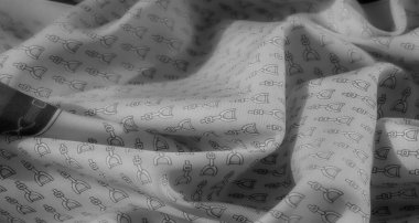 Yumuşak, dalgalı gri bir kumaş. Karmaşık üzengi desenleri etrafa saçılmış. Pürüzsüz dokusu ve monokrom estetiği lüks, binicilikten esinlenilmiş bir görünüm yaratır..