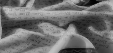 Enfes üzengi desenli gri bir kumaş zarif bir şekilde yüzeye yerleştirilmiş. Pürüzsüz dokusu ve zarif kıvrımları onu lüks tekstil tasarımının mükemmel bir somutlaşması yapıyor..