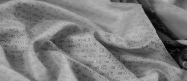 Yumuşak, dalgalı gri bir kumaş. Karmaşık üzengi desenleri etrafa saçılmış. Pürüzsüz dokusu ve monokrom estetiği lüks, binicilikten esinlenilmiş bir görünüm yaratır..