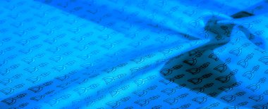 Soyut, dinamik düzende siyah üzengimsi desenli mavi kumaş. Tekstil, kıvrımlar ve doğal dokularla vurgulanmış, tekrarlayan binicilikten esinlenilmiş bir tasarıma sahip..