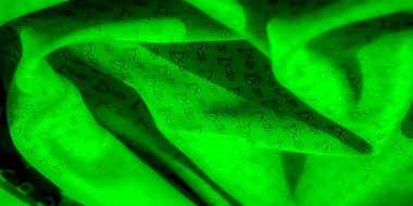 Ayrıntılı siyah üzengi desenli parlak yeşil bir tekstil. Kumaşlar doğal kumaş derinlik ve doku yaratır. Moda ve dekor için mükemmel hale getirir..