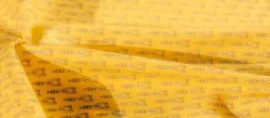 Hassas siyah üzengi desenli zarif sarı bir kumaş eşsiz ve ince bir doku yaratır. Tasarım kumaş boyunca akar, genel estetiğe cazibe ve binicilik yeteneği ekler..