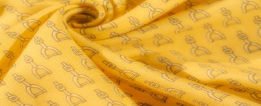 Bu kumaş, siyah üzengi desenli zengin sarı bir tabana sahip. Kumaş zarif bir şekilde akarken, binicilik temasını şık ve detaylı deseniyle yakalıyor..