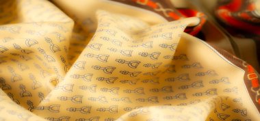 Canlı sarı bir kumaş ve üzengiye benzer desenler, klasik binicilik temalarını modern tasarım ile birleştiriyor. Ayrıntılar ve kıvrımlar görsel olarak çarpıcı bir etki yaratıyor..