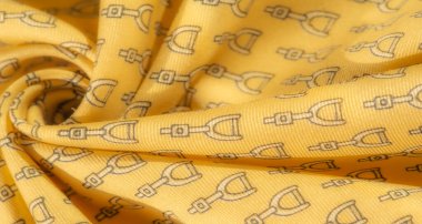 Karmaşık üzengi desenli, lüks, pürüzsüz sarı bir kumaş. Ev dekorasyonu ya da giysisi için şık, binicilikten esinlenilmiş bir tasarım arayanlar için ideal..
