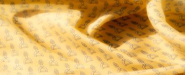 Bu resim, narin üzengi desenli sarı bir kumaşa sahip. Açık gölgeler ve pürüzsüz dokular, moda ve tasarım projelerinde kullanılmak için ideal, zengin, lüks bir his veriyor..