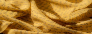 Siyah üzengi motiflerini tekrarlayan sarı kumaş yakın plan çekimleri dinamik ve binicilik esinlenilmiş bir tema oluşturuyor. Dokulu kumaş yüzeyi ve pürüzsüz katlar