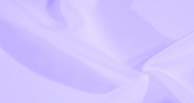 Yumuşak kıvrımlı bulanık mor kumaş soyut bir arkaplan yaratır. Yumuşak dalgalar huzur ve akıcılık hissi uyandırırken pürüzsüz madde ağırlıksız görünür..