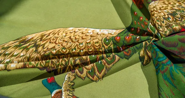 Renkli sülünler canlı yeşil kumaş arkaplanda gösteriliyordu, kırmızı, mavi ve altın renkli tüyler sergileniyordu. Doğa, kuş ve vahşi yaşam temaları için mükemmel.