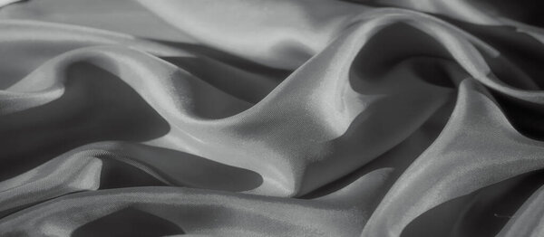 Потрясающий крупный план шелковой ткани, элегантно задрапированный, демонстрирующий ее мягкую текстуру. Гладкие складки и тонкое освещение создают ощущение движения, роскоши и утонченной простоты.