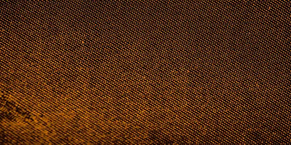 Sıcak kahverengi ve turuncu tonlarda desenli dokulu bir yüzeye yakın çekim. Bu ipek, küçük dairelerden oluşan ince bir şebeke, organik gibi hissettiren karmaşık bir dizayn yaratıyor..