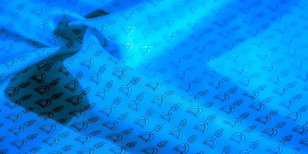 Pürüzsüz bir dokusu olan canlı mavi bir kumaş. Karmaşık siyah üzengimsi desenler içeriyor. Akan kıvrımlar derinlik ve boyut ekler, kumaşın yansıtıcı özelliklerini vurgular..