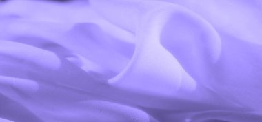 Narin kıvrımları ve pürüzsüz dokuları olan açık mor kumaşın bulanık görüntüsü. Malzemenin ince akışı yumuşaklık hissi veriyor, bu da onu minimalist tasarım ve rahatlatıcı görseller için mükemmel kılıyor..